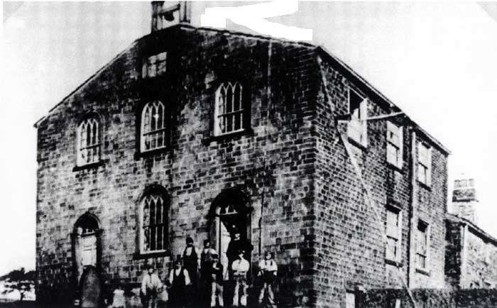 The original 1830 stone chapel with a small group of men outside